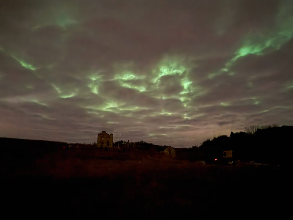 Photograph of green aurora shining through clouds: Bob Hamers.